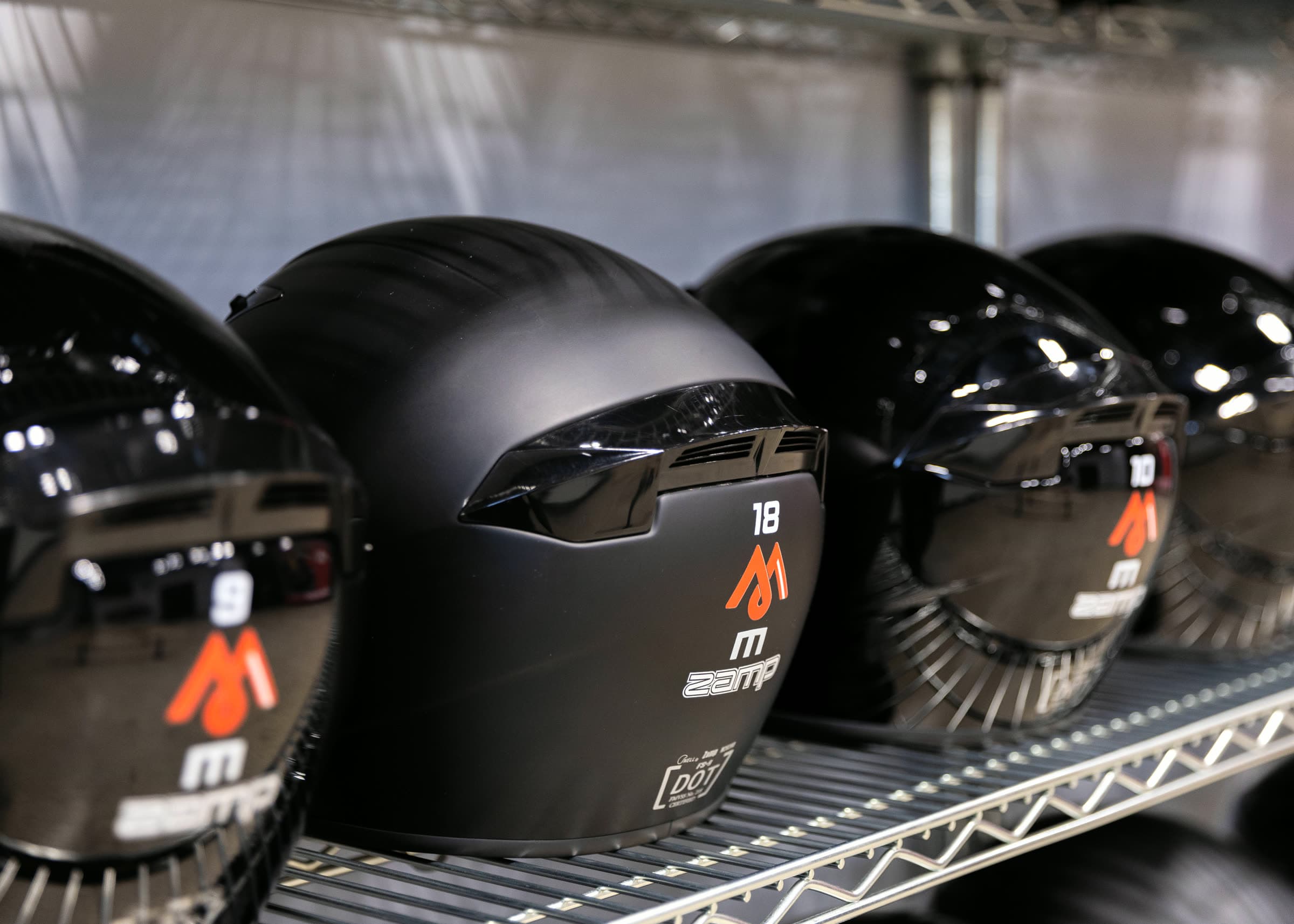 Rack of numbered MCK helmets in the pit building
